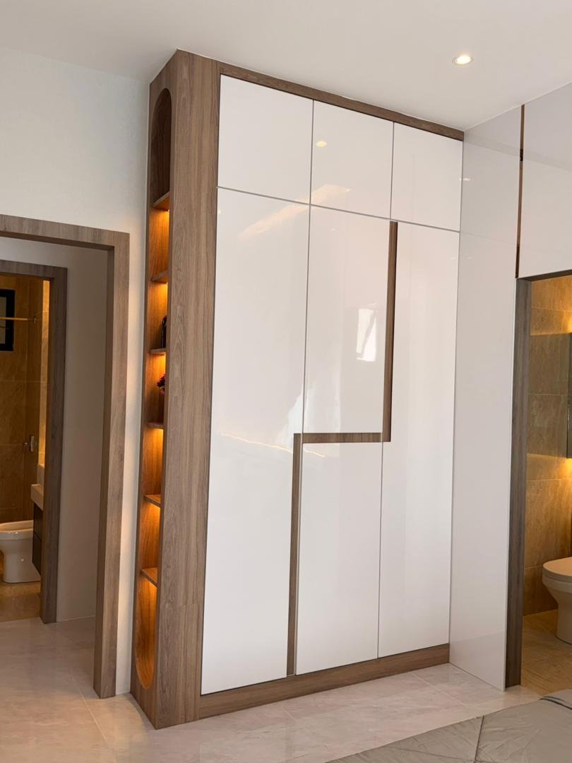 Walnut-framed white gloss entry wardrobe with arched lit niche shelving, Klebang showroom