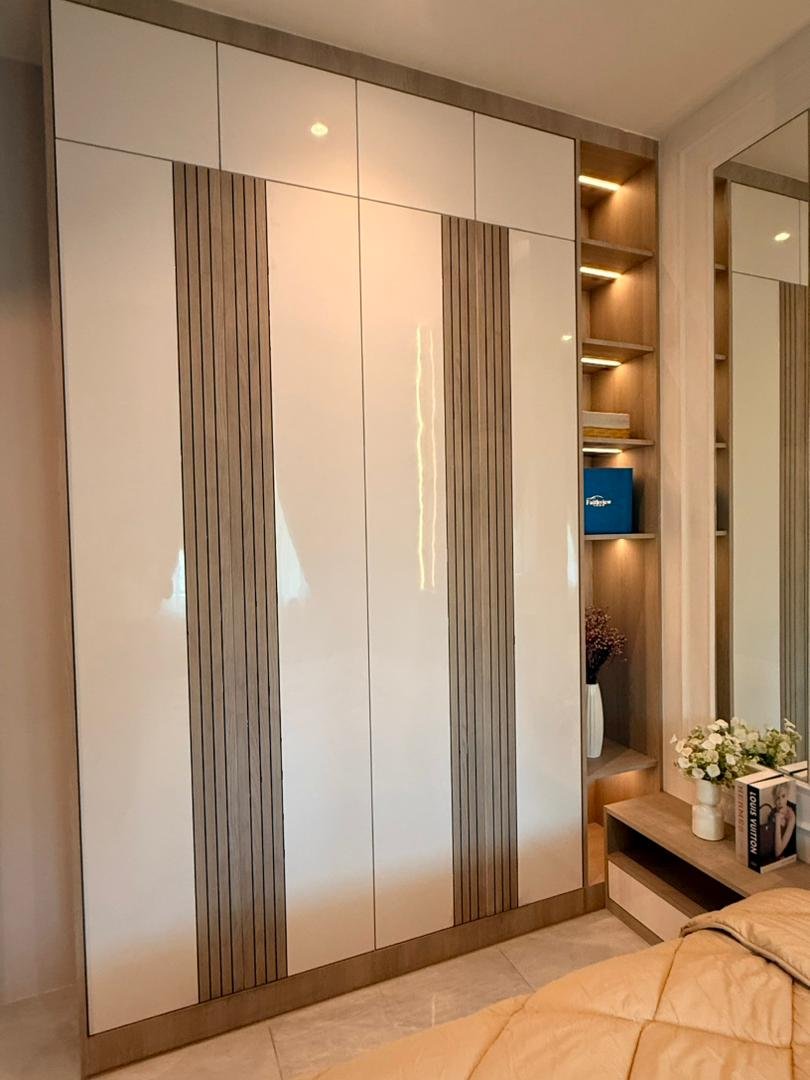 Master bedroom wardrobe in white gloss with vertical fluted inserts and lit open niche, Klebang showroom